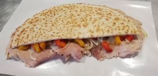Piadina con porchetta, scamorza, cipolla, peperoni e crema di funghi