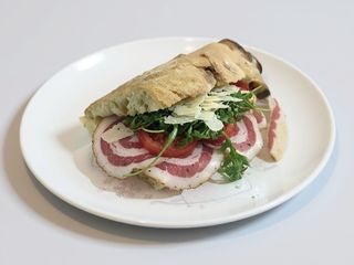 Pomodori a fette, fiordilatte, rucola, grana e pancetta arrotolata