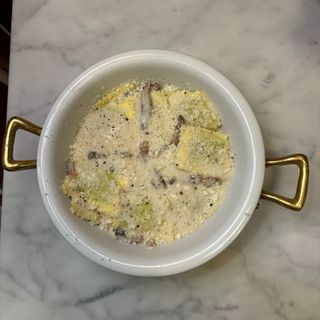 Ravioli ricotta e spinaci con crema di cacio e pepe e guanciale croccante