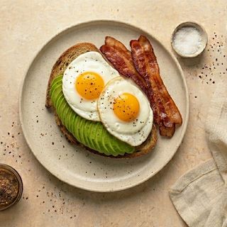 Uova occhio di bue con bacon, avocado e pane tostato