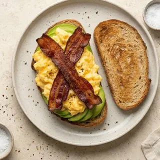Uova strapazzate , avocado, bacon e pane