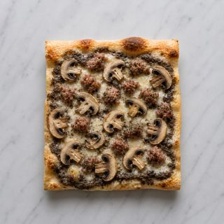 Pizza bianca con salsiccia, funghi, salsa di tartufo noci e mozzarella
