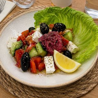 Insalata greca con salsa vinaigrette e foglie di lattuga iceberg