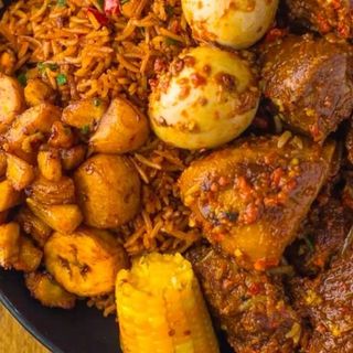 Jollof rice, plantains, 2 boiled eggs, boiled sweetcorn and beef in Nigerian spicy sauce 