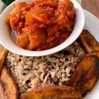 White rice mixed with beans serve with plantains and cowleg 