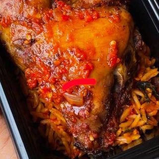 Jollof rice, boiled egg and peppered piece of turkey