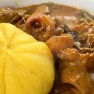Ogbono mixed with Assorted meat served with yellow eba 