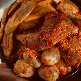 Jollof rice, plantains, 4 boiled eggs mixed with traditional chicken 
