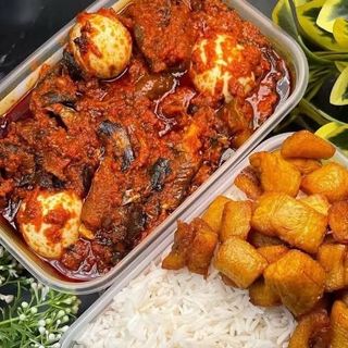 White rice, plantains, fried titus fish stew mixed with 3 boiled eggs 