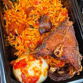 Jollof rice, boiled egg and peppered nile perch fish