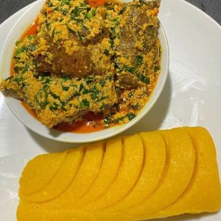 Yellow Eba served with egusi mixed with pomo