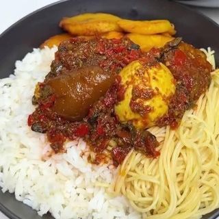 Half white rice, half Sphaghetti, plantains, spicy cowleg mixed with boiled egg 