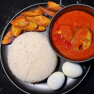 White rice and plantains served with titus fish in spicy stew mixed with 2 boiled eggs