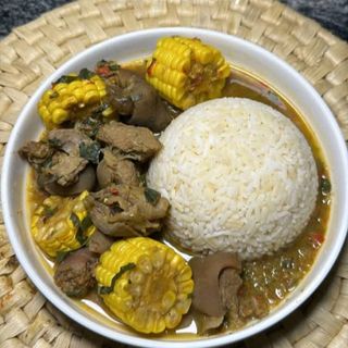 White rice served with goatmeat peppe soup mixed with corn