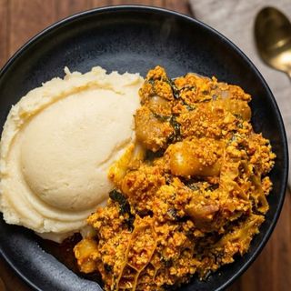 Semolina served with egusi mixed with pomo and croaker fish