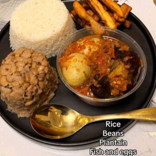 Half White rice with half oloyin beans, plantains served with titus fish and 2 boiled eggs