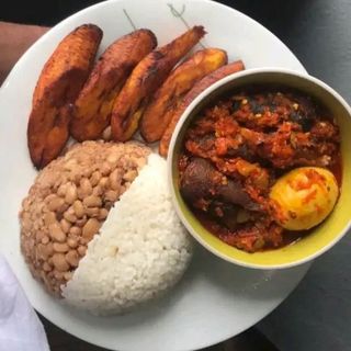 Half white rice,half oloyin beans with plantains, served with 1 boiled egg in pomo spicy stew