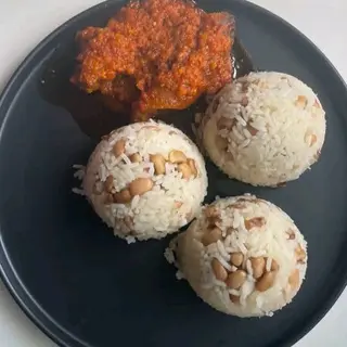 White rice mixed with oloyin beans served with spicy beef stew