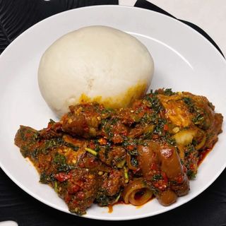 Pounded yam served with eforiro mixed with titus fish, chicken and pomo