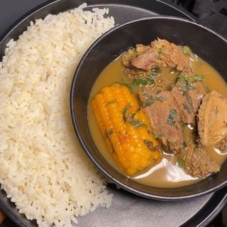 White rice served with goatmeat peppe soup and boiled sweetcorn