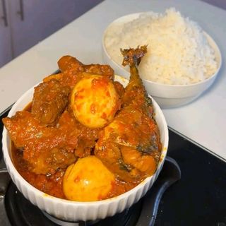 White rice served with pomo beef croaker fish and 2 boiled eggs