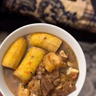 Boiled plantains mixed with goatmeat peppe soup