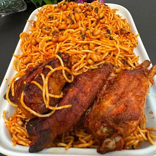 Jollof spaghetti mixed with white oloyin beans served with 3 pieces of peppered chicken