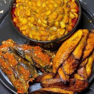 White Oloyin beans porridge served with plantains and titus fish