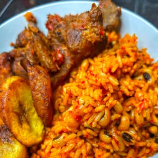 Jollof rice mixed with white oloyin beans served with plantains and chicken
