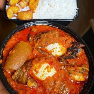 White rice Plantains served with peppered pomo beef croaker fish and 2 boiled eggs