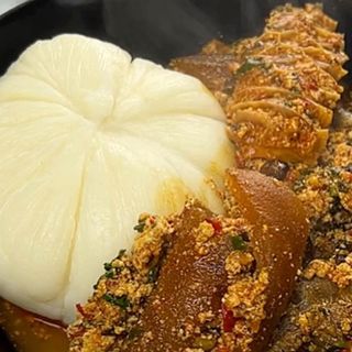Pounded yam served with egusi mixed with chicken, shaki and pomo 