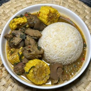 White rice served with goatmeat peppe soup mixed with sweet corn