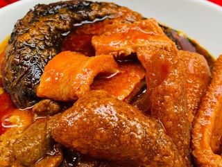 Titus fish mixed with pomo and shaki in peppered Nigerian sauce