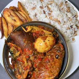 White rice mixed with oloyin beans plantains served with pomo mixed with titus fish and turkey meat