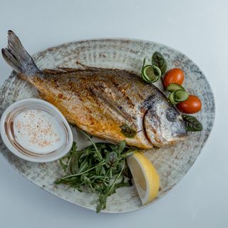 Дорадо на углях с сырным соусом и с миксом из зелени . 