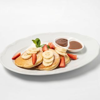 Панкейки с гранолой, мороженым, шоколадным и соусом, клубникой и бананом