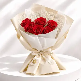 Bouquet de roses Rouge emballé dans un papier blanche  et beige crémé