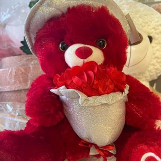 دبدوب مع قبعة فضية يحمل باقة ورد للغاليين