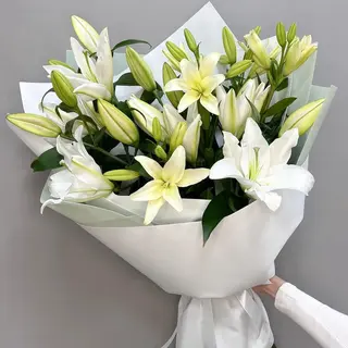 Bouquet de lys blancs généreux à 7 tiges, élégamment emballé.