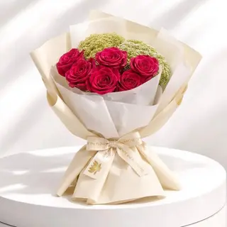 Bouquet de roses fuchsia  emballé dans un papier blanche et beige crémé