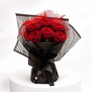 Bouquet de roses Rouge emballé dans un papier noir  et noir rayée