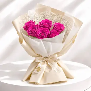 Bouquet de roses Fuchsia  emballé dans un papier blanche  et beige crémé