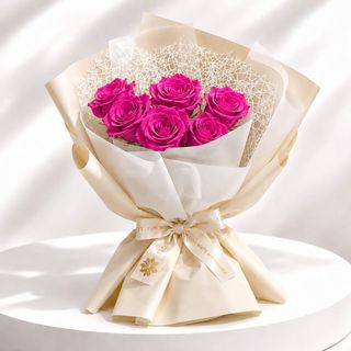 Bouquet de roses Fuchsia  emballé dans un papier blanche  et beige crémé