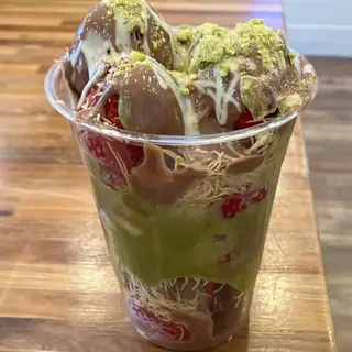 un cup gourmand composé de kunafa croustillante, de fraises fraîches et d’une généreuse sauce Nutella