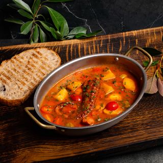 Tentacule de caracatiță cu cartofi și capere în sos de roșii, servite cu pâine