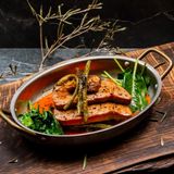 Steak de ton așezat pe pat de legume și îmbogățit cu sos Romesco