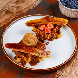 Vafe cu sos de caramel și banană caramelizată alături de înghețată