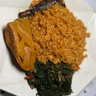 Jollof rice with Moimoi Titus and steamed veggies