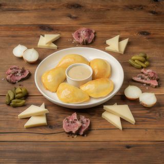 Pierogi z pieca z wołowiną smażoną w sosie kentucky z boczkiem, serem cheddar, piklami i cebulą prażoną