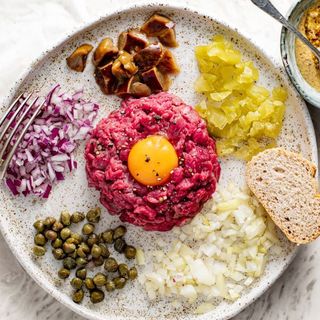 Tatar wołowy ,mięso wołowe ,jajko ,ogórek, cebulkaprzyprawy, bułka